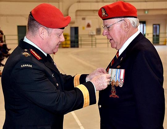 Photo of Bob Thomas receiving award from BGen Delaney, CF Provost Marshal.